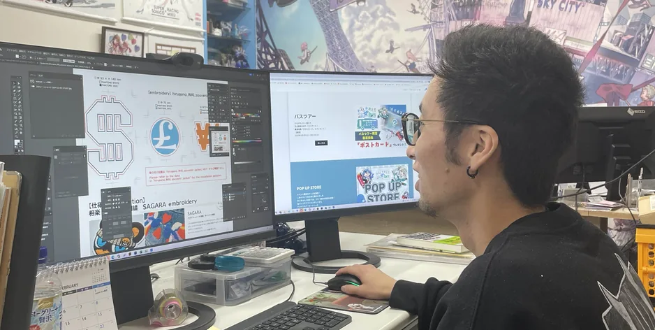 モニターに向かってデザイン制作をするスタッフ