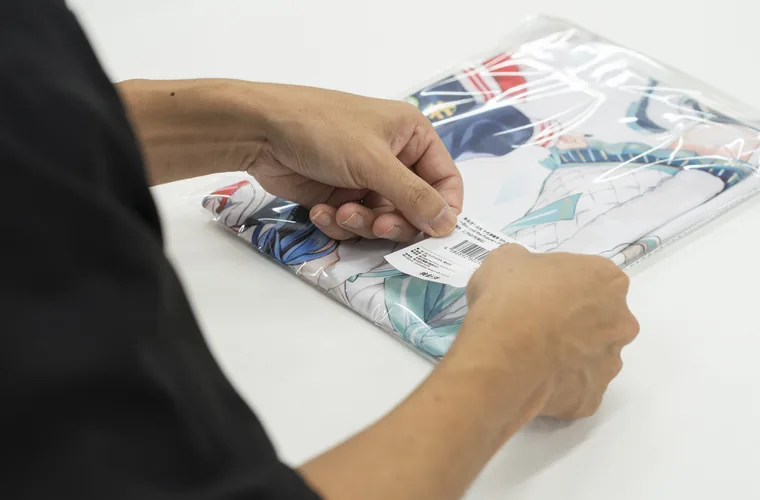 袋詰めした商品にシールを貼る作業の様子